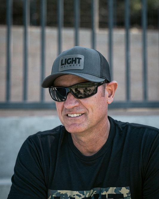 Man wearing a cap and sunglasses with a blurred background