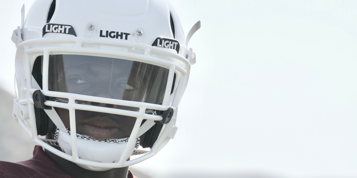 Football player wearing a white LIGHT LS2 football helmet