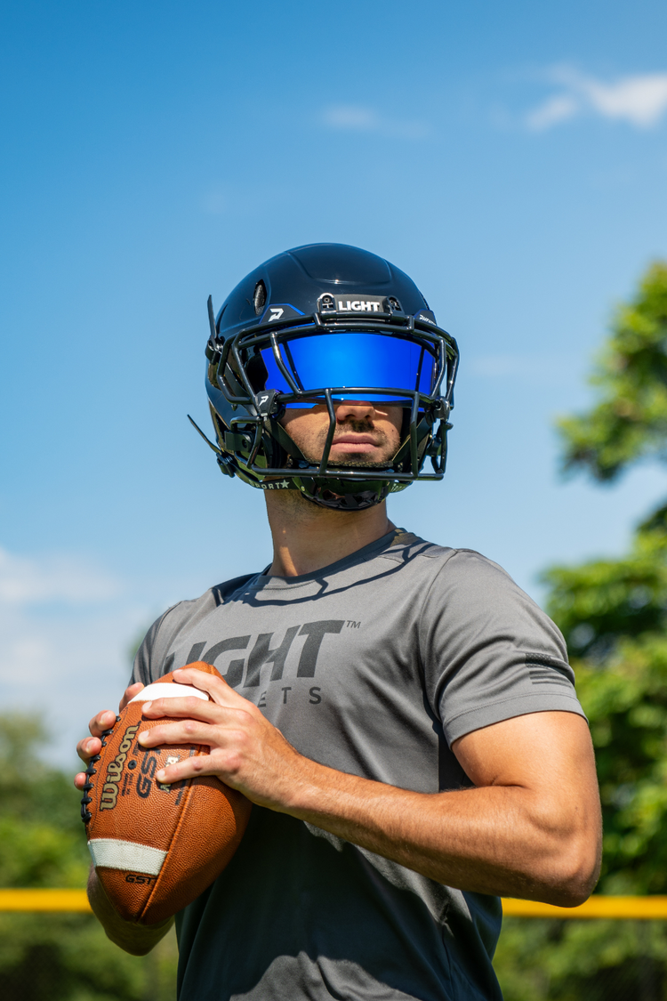 Football player wearing a gloss black LIGHT LS2 football helmet with a Phenom blue tint visor