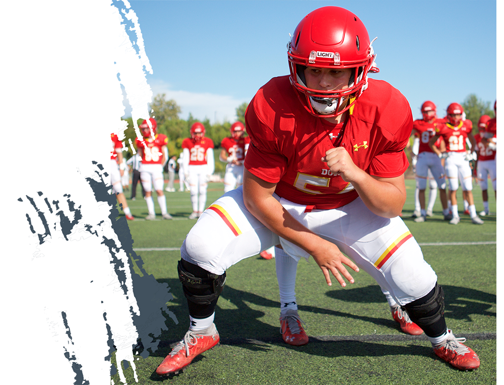 Youth football player wearing a LIGHT LS2 Red Football Helmet playing on the football team